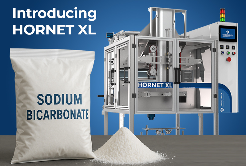 A Vertobagger Hornet XL machine next to a sodium bicarbonate pillow bag and powder pile on a blue background.
