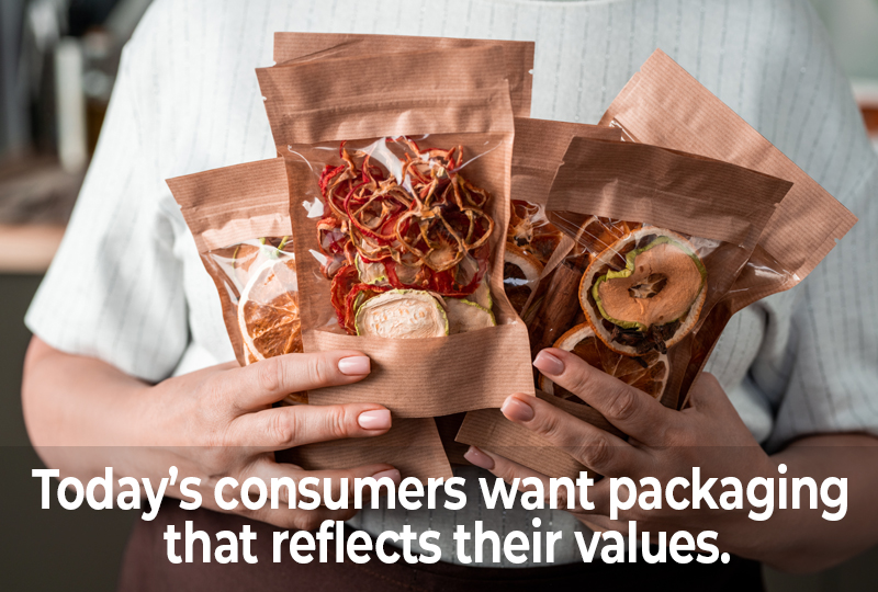 A person holding eco-friendly brown paper snack pouches filled with dried fruits and vegetables, highlighting sustainable snack packaging trends.
