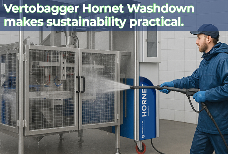 Technician cleaning a Vertobagger Hornet Washdown VFFS machine with a high-pressure hose in a food production facility.