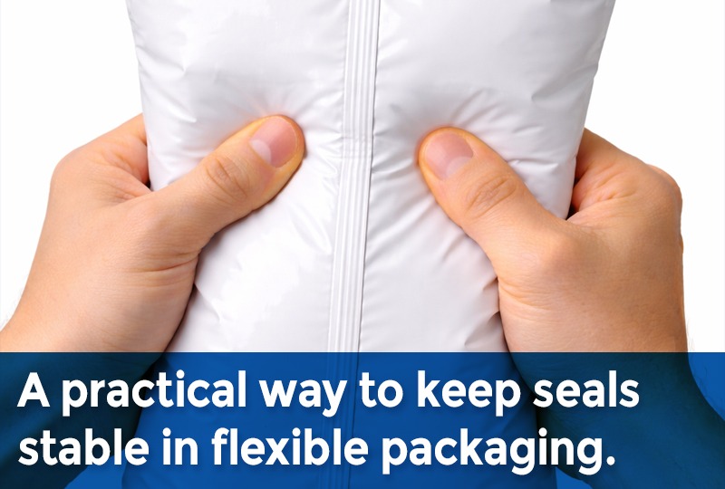 Hands pressing on a flexible packaging pouch to test seal integrity along the center seal.