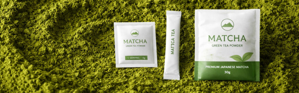 Matcha green tea powder packaging in sachet, stick pack, and pouch formats on a bed of matcha powder